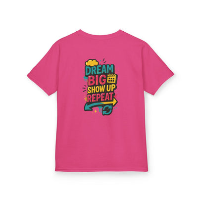 Back view of a pink kids tee featuring motivational text: Dream Big. Show Up. Repeat.