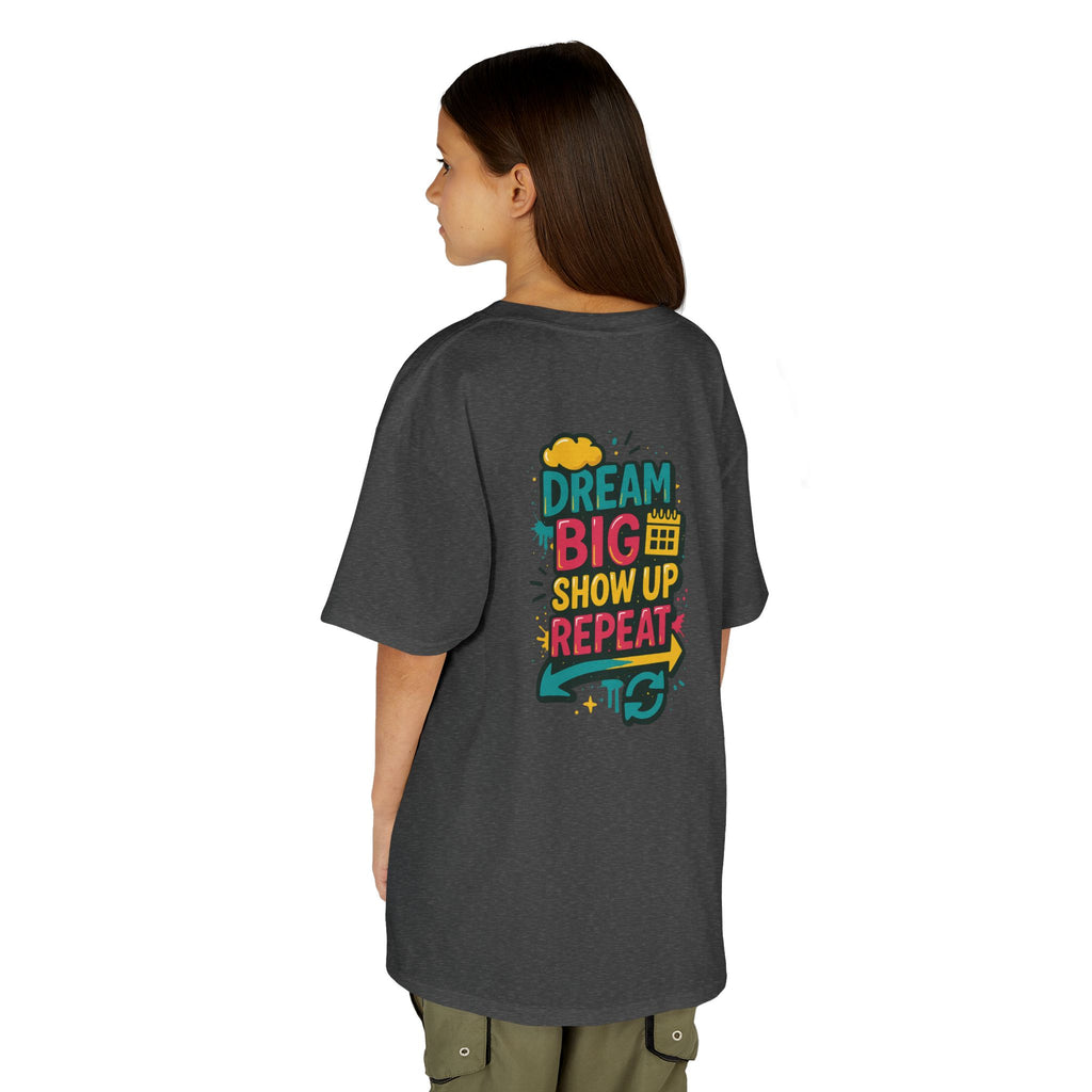 Back view of a gray kids tee with colorful text: 'Dream Big. Show Up. Repeat.' for motivational back-to-school style.