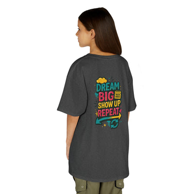 Back view of a gray kids tee with colorful text: 'Dream Big. Show Up. Repeat.' for motivational back-to-school style.