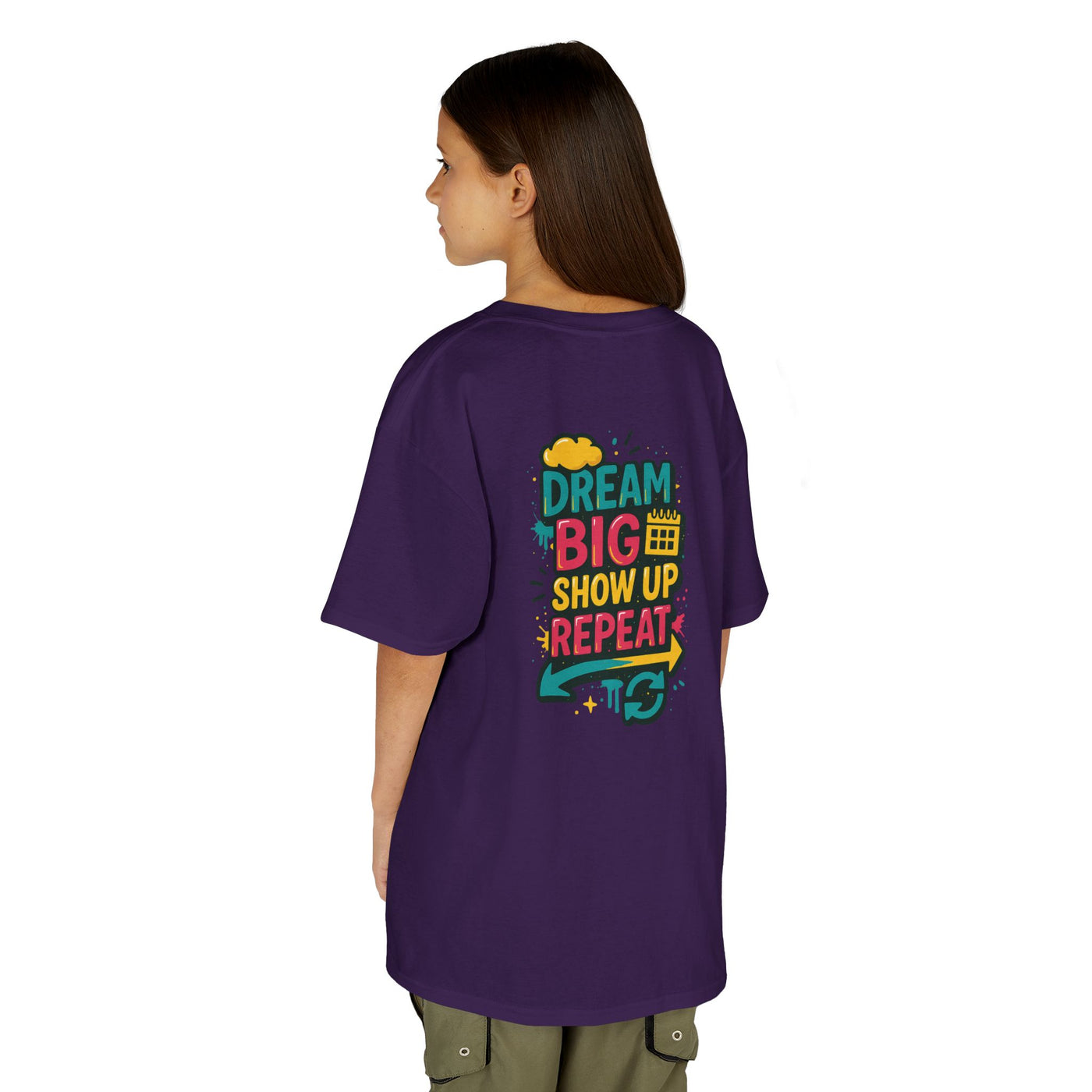 Back view of kids purple tee with 'Dream Big. Show Up. Repeat.' motivational message, perfect for back-to-school.