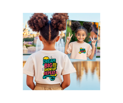 Child wearing 'Dream Big. Show Up. Repeat.' motivational kids tee, showcasing vibrant colors and empowering message.