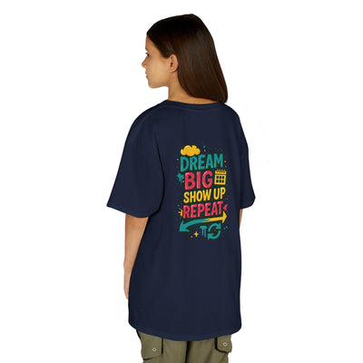 Motivational kids tee featuring 'Dream Big. Show Up. Repeat.' graphic on back, perfect for back-to-school inspiring confidence.