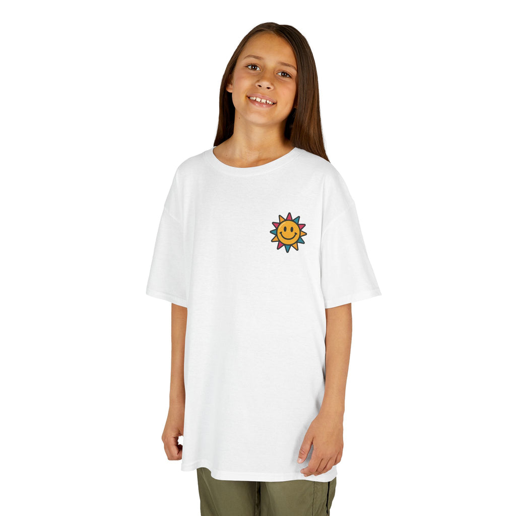 Smiling child wearing white 'Be The Reason Someone Smiles Today' tee with sun graphic, perfect for back-to-school.