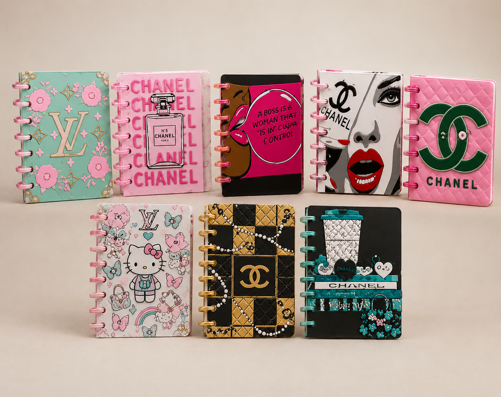 A set of eight mini spiral-bound notebooks featuring various pop culture and fashion designs, including Chanel, Louis Vuitton, Hello Kitty, and a black-and-white face graphic, arranged in two rows on a light beige background.