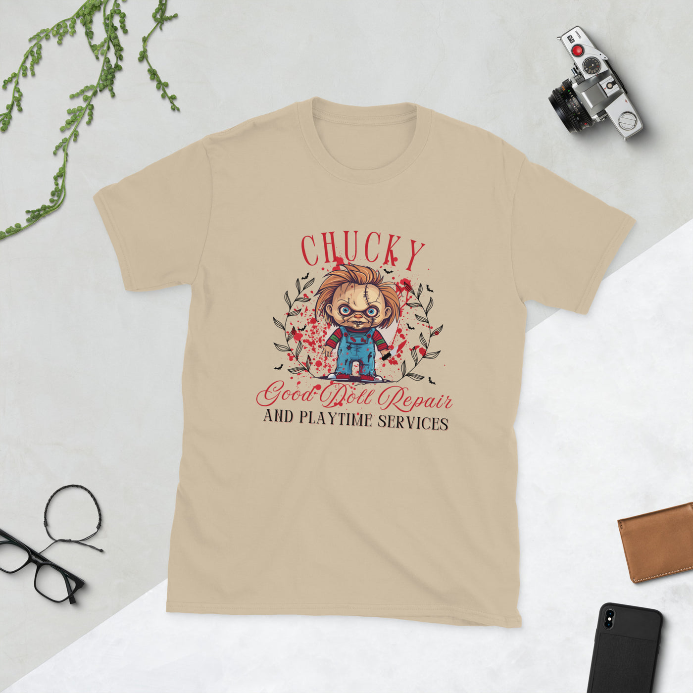 Chucky-themed Halloween tee featuring doll repair and playtime services design on a beige shirt.
